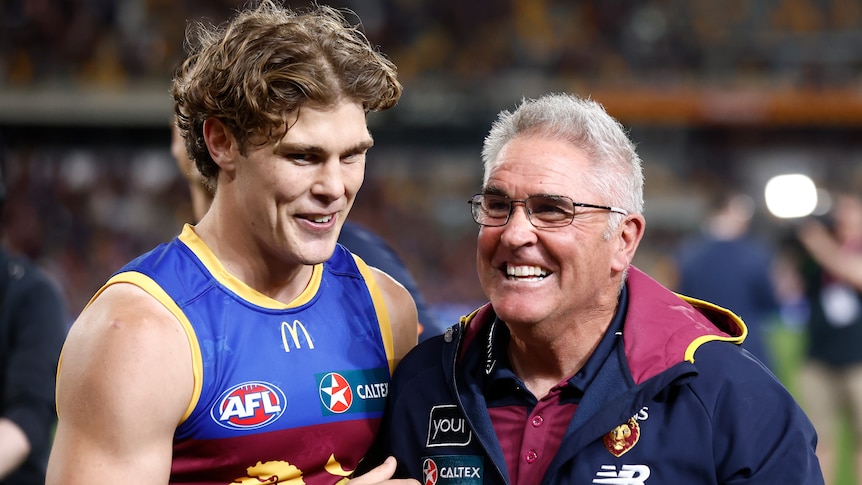 Deven Robertson (left) and Chris Fagan stand together and smile after the Lions beat the Blues in their AFL preliminary final.