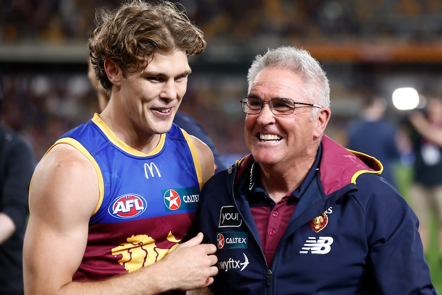 Deven Robertson (left) and Chris Fagan stand together and smile after the Lions beat the Blues in their AFL preliminary final.