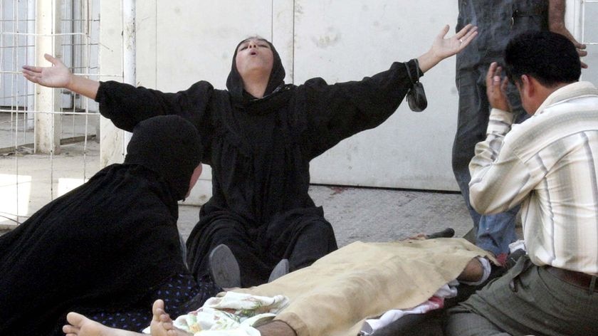 An Iraqi woman grieves over the body of a man