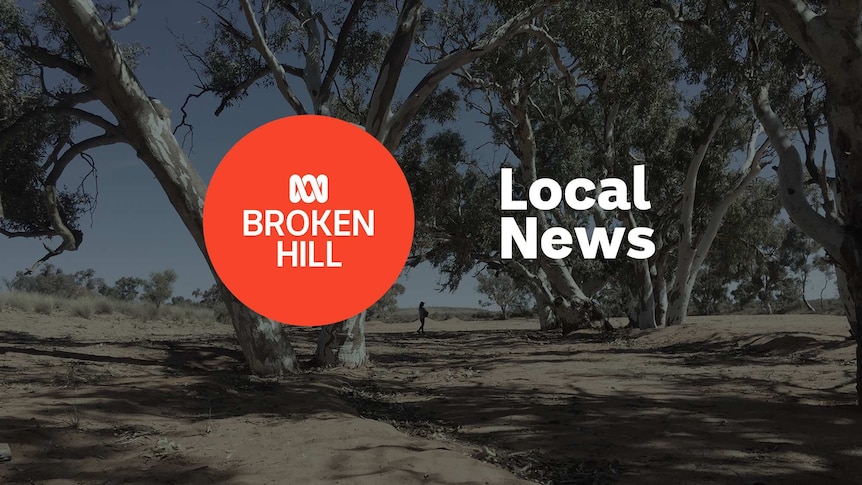 Dry riverbed with giant gum trees; ABC Broken Hill and Local News superimposed over the top.