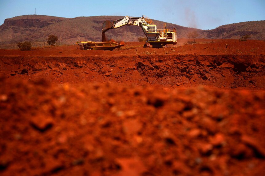 A giant excavator loads a mining truck at the Fortescue Solomon iron ore mine near Port Hedland.