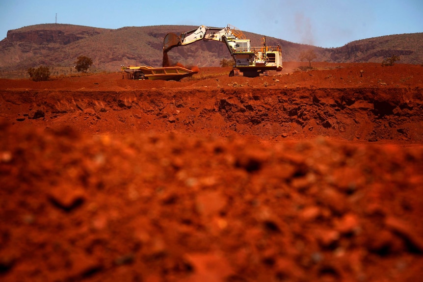 A giant excavator loads a mining truck at the Fortescue Solomon iron ore mine near Port Hedland.