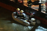 A boat with rescuers moors next to a landing dock in the Danube River.