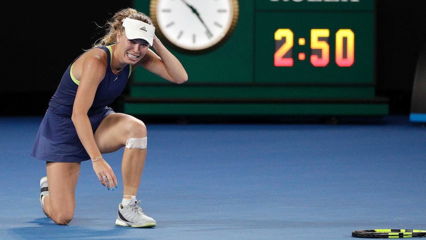 Caroline Wozniacki on the ground after winning the Australian Open final against Simona Halep.
