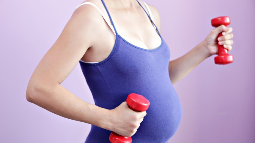 Pregnant woman using dumbbells during a workout.