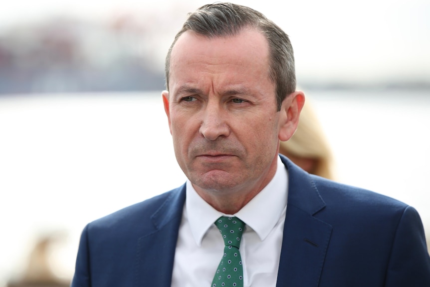 A head and shoulders shot of Mark McGowan looking grim while talking at a media conference. 