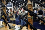 Gun enthusiasts inspect a collection of guns at the NRA's annual meetings and exhibits show.
