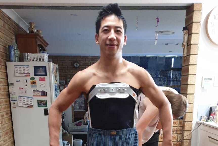 Acrobatic performer Anthony Tran wearing a back support device.