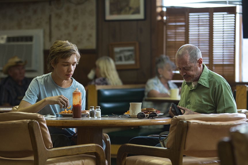 Colour still of Charlie Plummer and Steve Buscemi sitting and eating in a diner in 2018 film Lean on Pete.