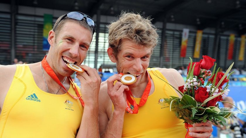 David Crawshay and Scott Brennan bite their gold medals for the men's double sculls final at the Bei