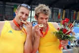 David Crawshay and Scott Brennan bite their gold medals for the men's double sculls final at the Bei