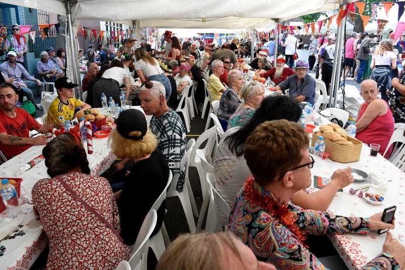 People sitting in rows along tables eating.