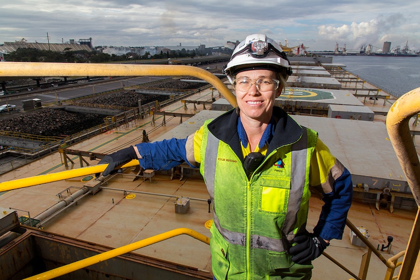 Kylie Ridgway stands on a platform above a coal ship.