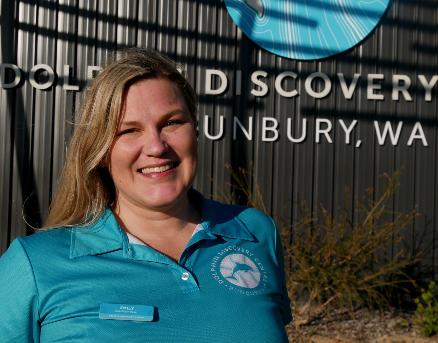 A woman in  blue shirt in front of Dolphin Discovery Centre