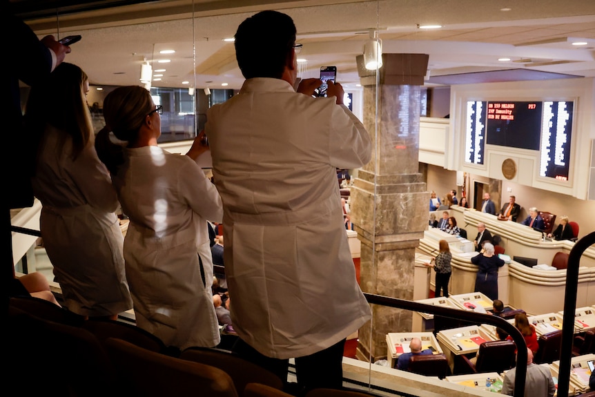 Doctors from the Alabama Fertility Clinic takes photos of the votes as the debate over the bill.