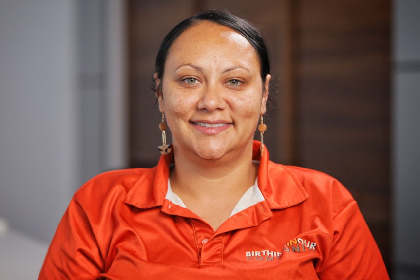 A woman wearing an orange shirt.