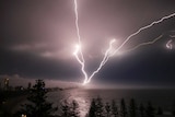 Multiple lightning strikes looking over the beach towards the Gold Coast