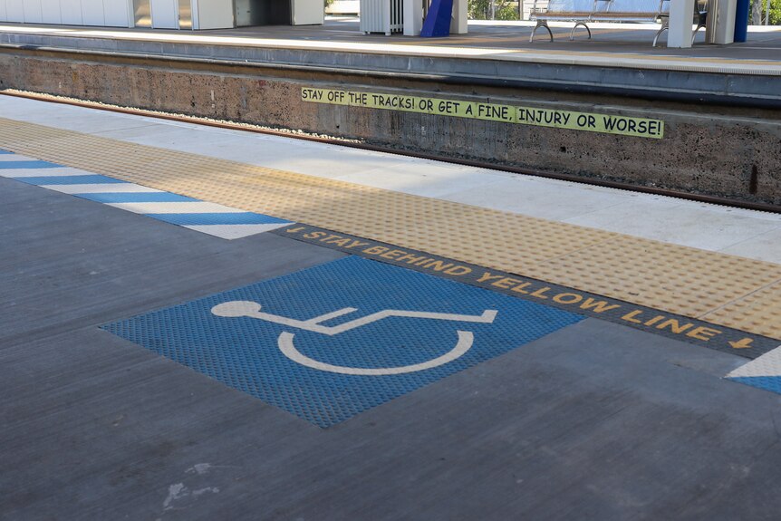a generic image of a blue wheelchair accessibility sign on a train station platform