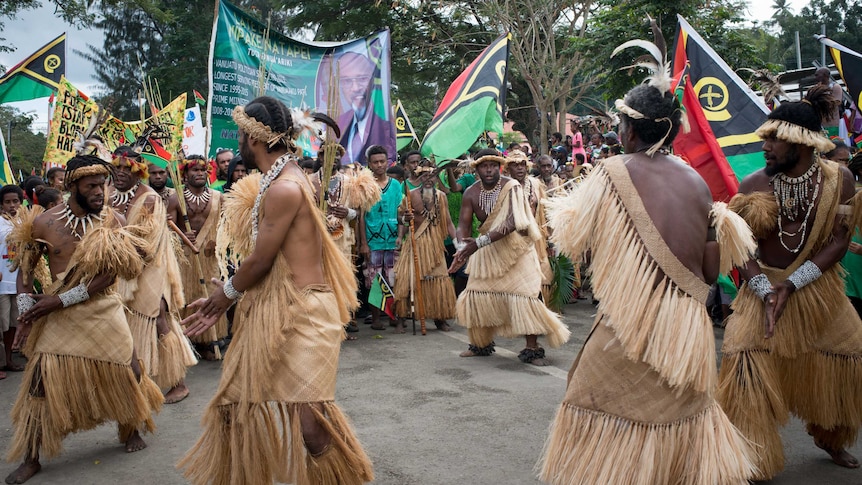 Men in traditional dress dance as part of Independence Day celebrations.