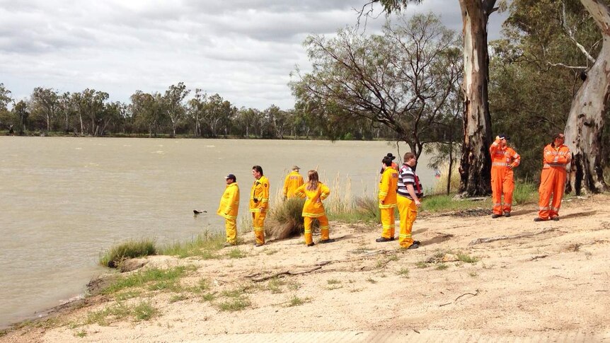 Police and SES personnel arrive at the Murray to search for a man missing after a boat capsize.