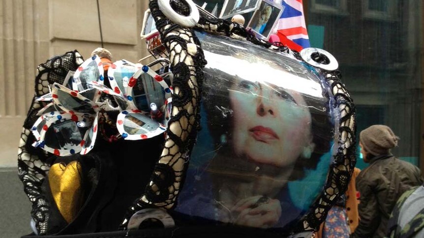 A mourner wears a Margaret Thatcher-themed hat