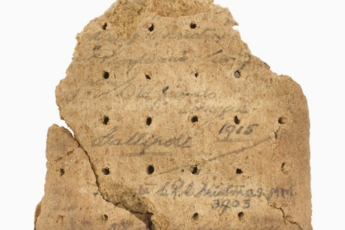 A broken oat biscuit given to an Australian soldier that shows writing on the back saying Merry Christmas, Gallipoli, 1915