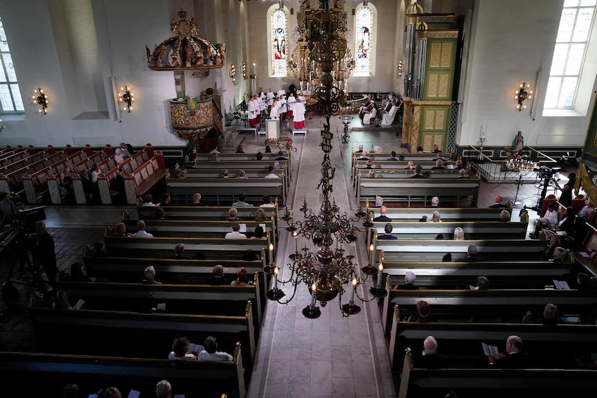 People sit during the memorial service at Oslo Cathedral