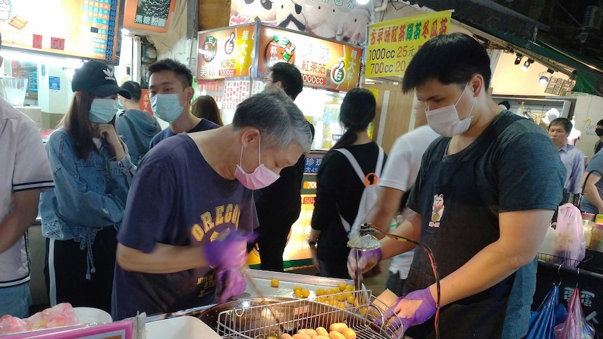 Vendors wear face masks to protect against the spread of the coronavirus at a night market in Taipei.