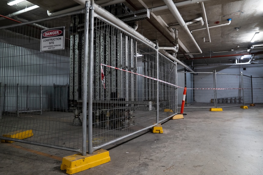 Temporary fencing around large metal columns in a basement