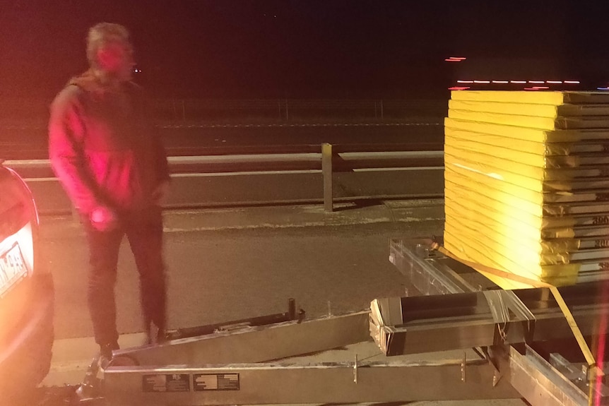 Dad standing on a freeway in front of a trailer