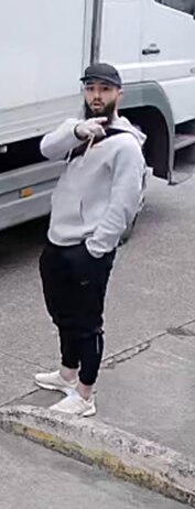 A man with a hat pointing towards the camera