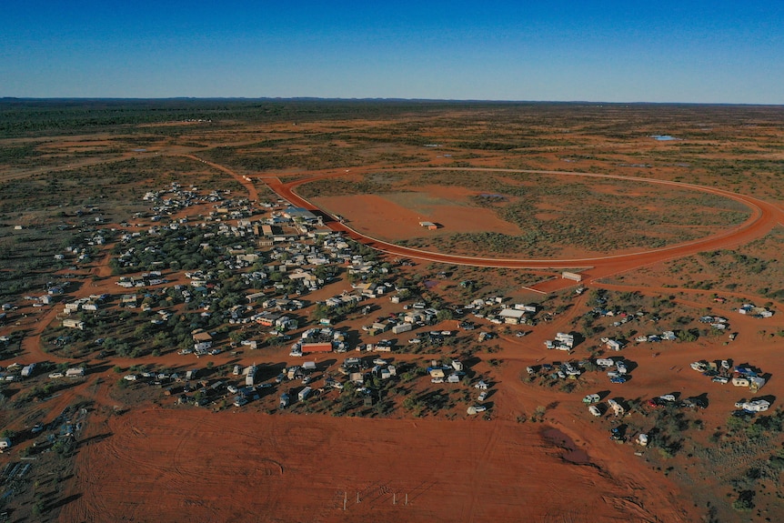 Picture from the air of red dirt, caravans and a race track