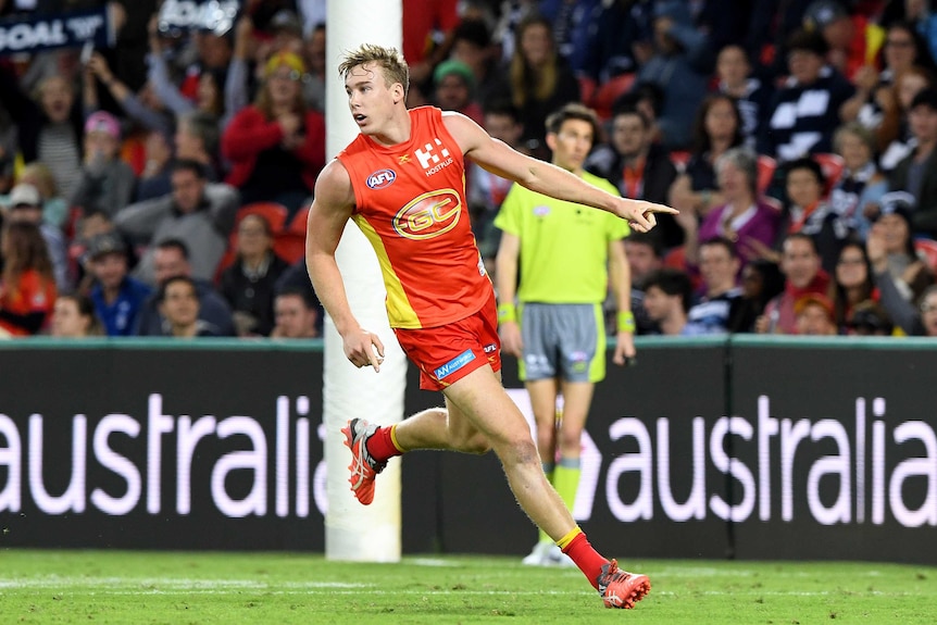 Tom Lynch looks back over his shoulder after kicking a goal for the Suns against the Cats.