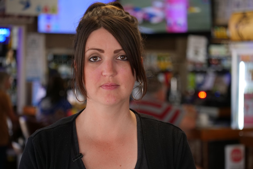 Close-up of a woman standing behind a bar.