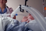 A nurse tends to a patient in an intensive care unit