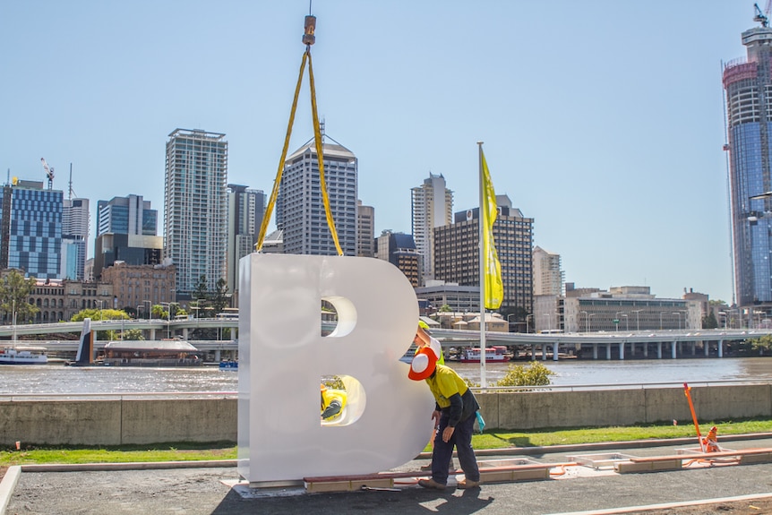 The letter B is put in place guided by engineers on the Brisbane River.