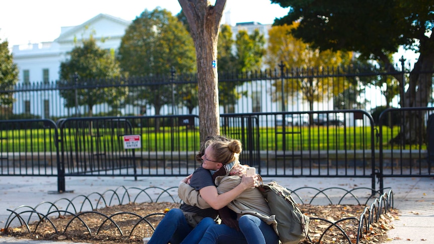 Women console each other outside the White House on the day of US election
