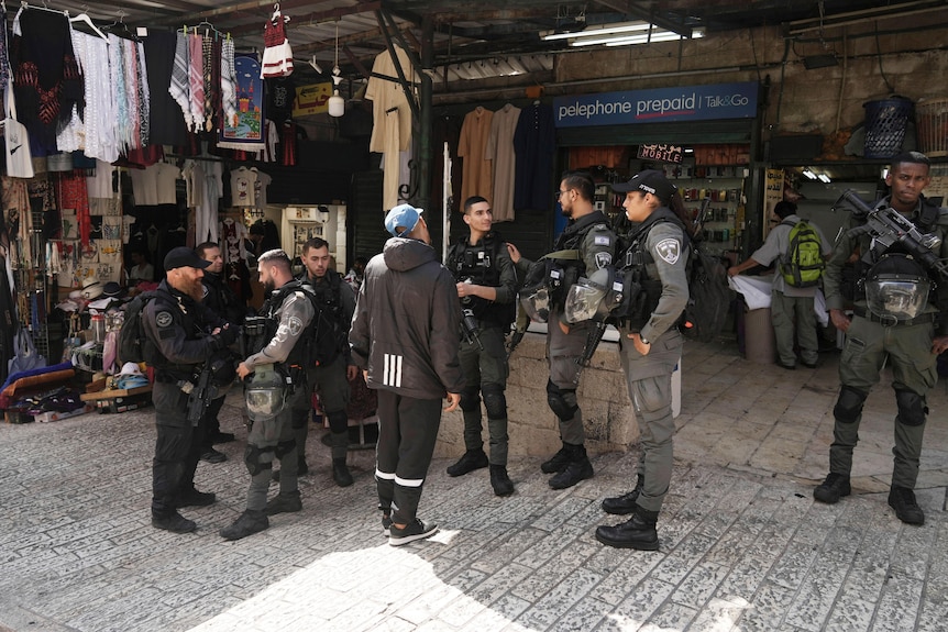 Israeli police stand guard outside shops in the Old City of Jerusalem.