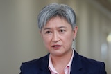 A close shot of Penny Wong, who has short grey hair, speaking indoors with a neutral expression.