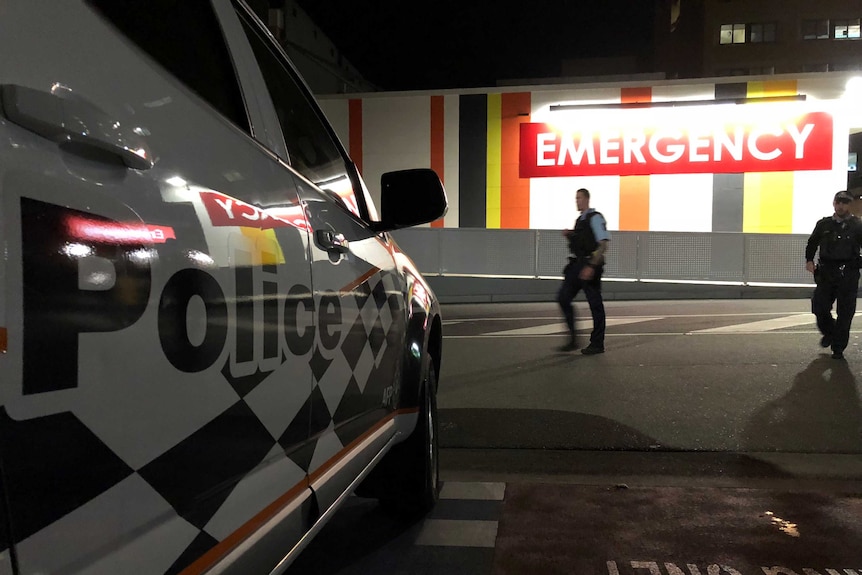 Police officers and a car outside the emergency department.