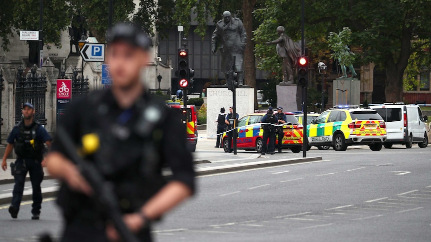 Armed police stand in the street after a car crashed outside the Houses of Parliament in Westminster, London.