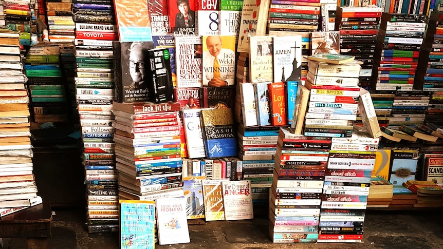 Books of many different genres stacked high for selling