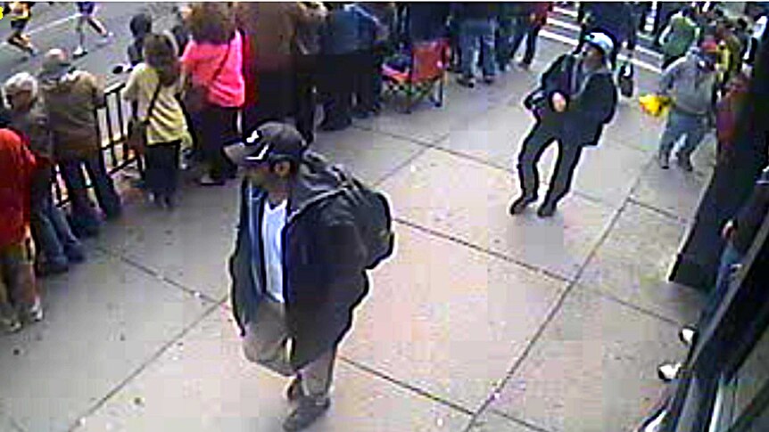 Suspects One and Two walk through the crowd.