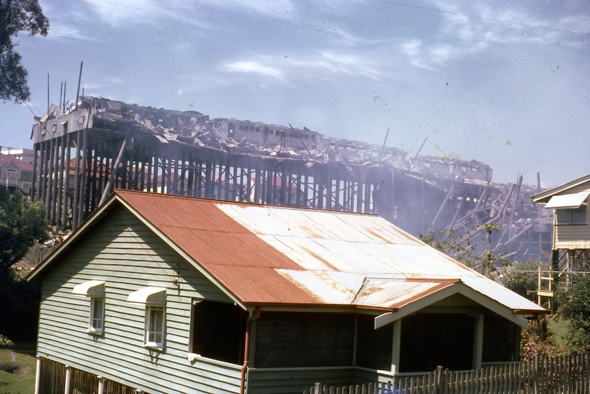 Trams burning in a timber building above a house