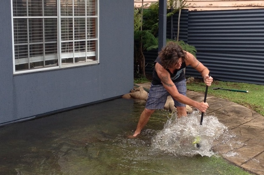 A Carrington resident attempts to keep floodwaters away from his home.