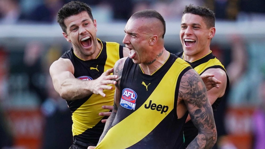 Dustin Martin celebrates a goal by stretching his black and yellow singlet