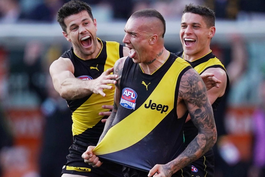 Dustin Martin celebrates a goal by stretching his black and yellow singlet