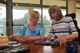 Two women in their 70s interacting at a table