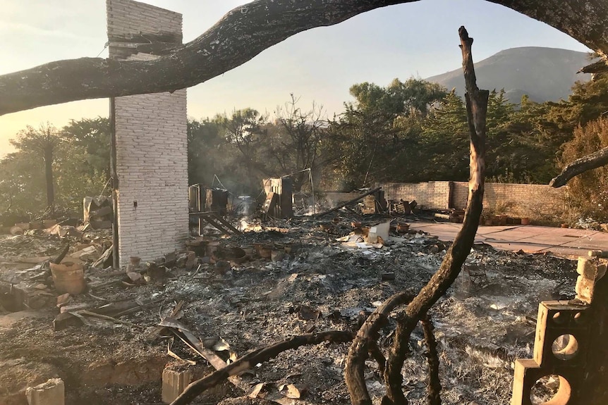 Smoke rises from the burned remains of a house in Malibu