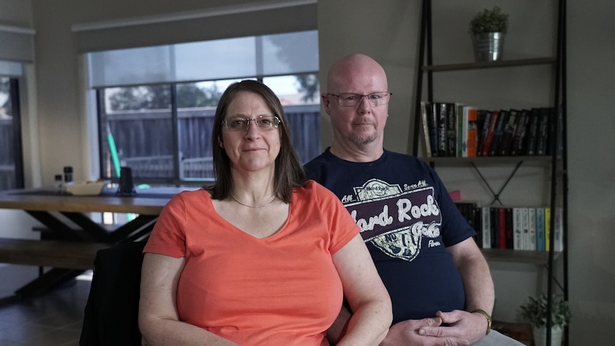 Sam and Wayne sitting together and looking at the camera in their living room.